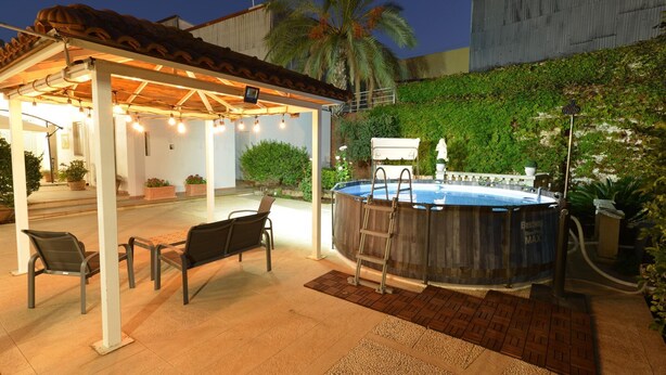 Une terrasse extérieure dotée d’un espace salon couvert, d’un jacuzzi et d’une piscine.