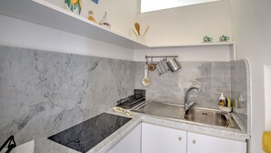 A modern kitchen with a marble backsplash, a built-in stove, and a sink.