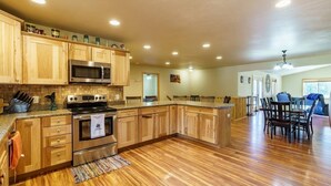 A spacious kitchen with wooden cabinets, a stainless steel oven, and a microwave. - Custer Connection- Private Retreat: 6-Acre Nature Escape with Trail Access, Custer. (Custer)