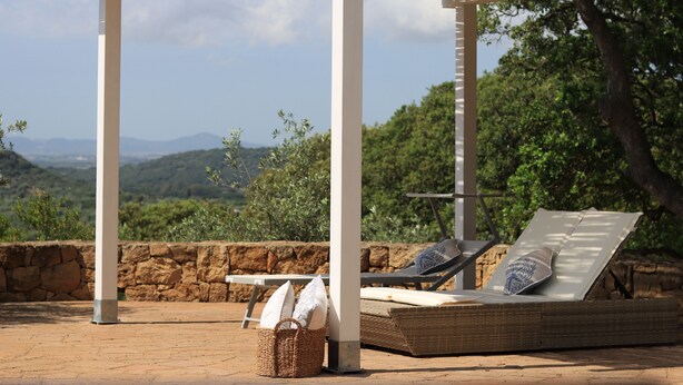 A covered outdoor seating area with a stone wall and a view of the landscape. - Villa Mirasol with sea and panoramic view, ideal for 4 people with AC and WiFi (Sardegna)