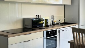 A modern kitchen with a built-in oven, a dishwasher, and a microwave.