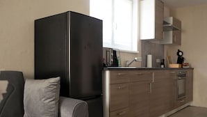 Una cocina moderna con refrigerador integrado, armarios de madera y un ventanal que proporciona luz natural.