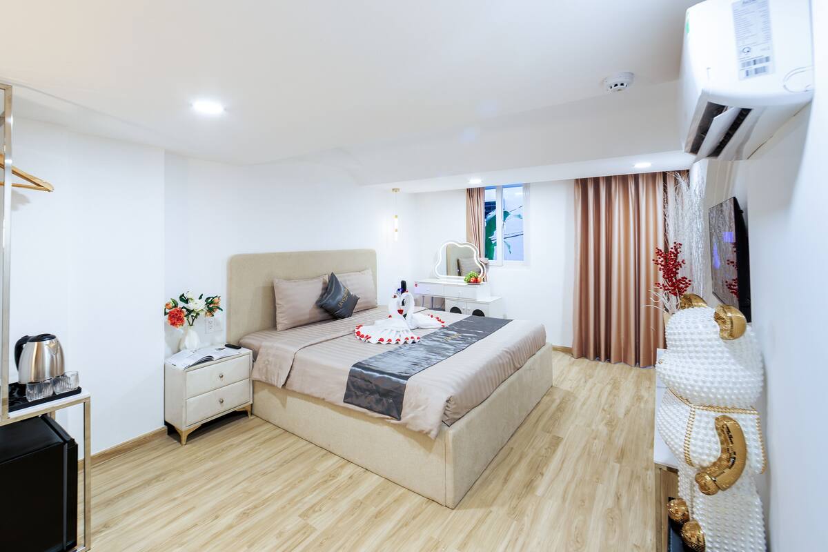 Ein modernes Hotelzimmer mit Bett, Nachttisch und Kleiderschrank.