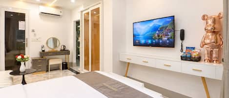 Una habitación de hotel moderna con una cama, un televisor, un escritorio, un espejo y una estatua de oso.