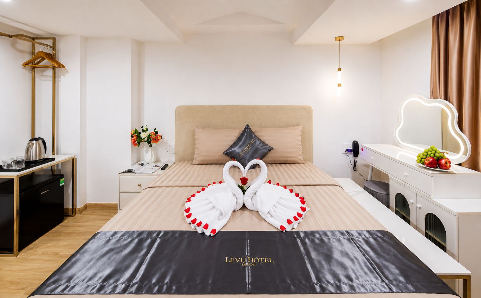 Una camera d'albergo con un letto, un comodino, una scrivania e uno specchio.