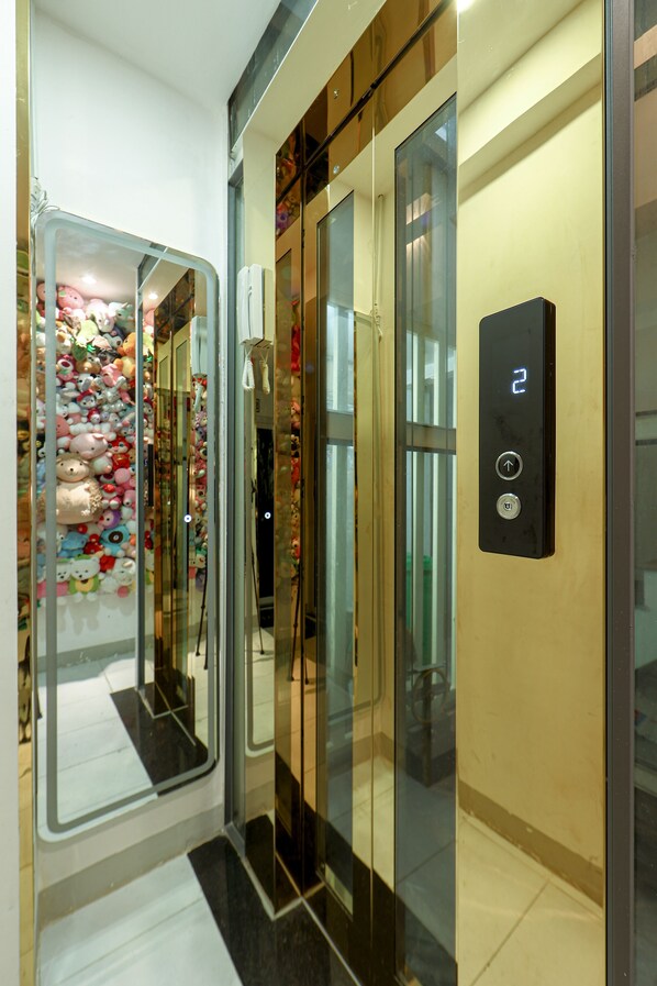 An elevator interior with a digital display showing the number 2, a mirror on the left, and a glass door with plush toys visible through it. - Le Vu Hotel (Ho Chi Minh City)