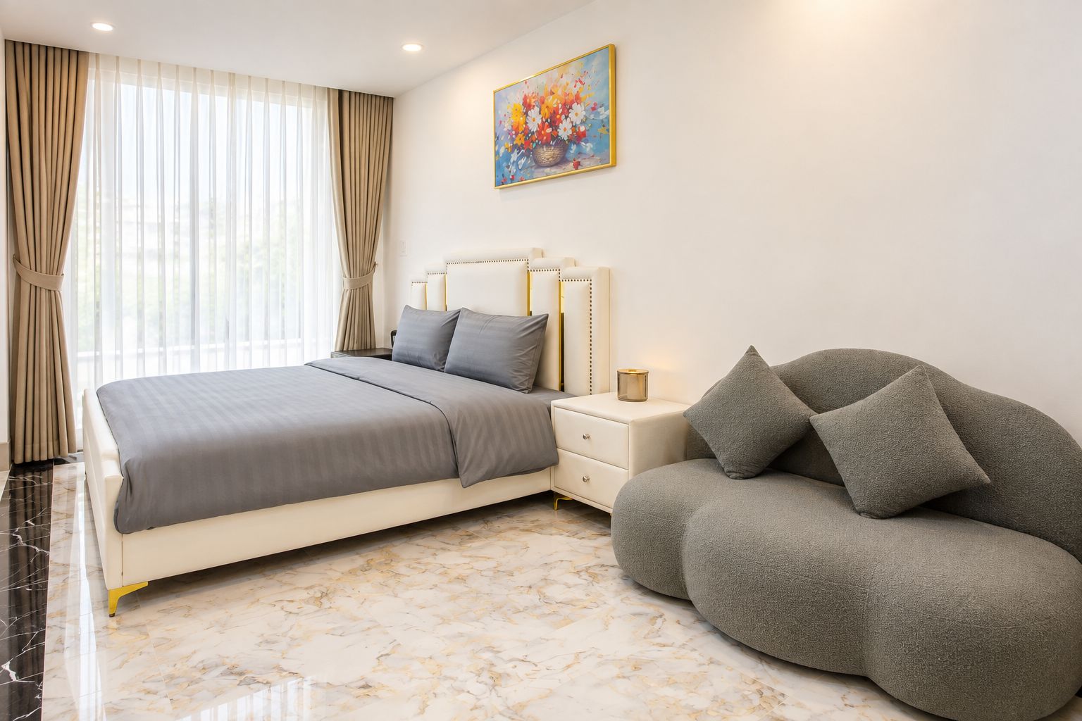Ein Schlafzimmer mit einem Bett, Nachttischen, einem Sofa und einem Gemälde an der Wand.