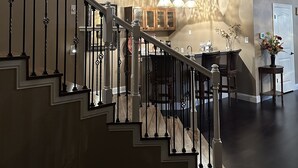 Un intérieur spacieux comprenant un escalier, un coin repas et une cuisine.