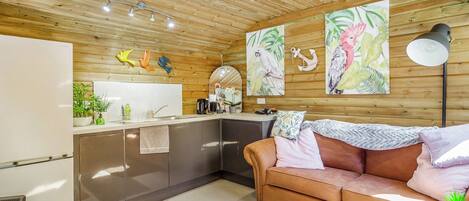 Une cuisine moderne avec un plafond en bois, un canapé et des œuvres d’art accrochées aux murs.