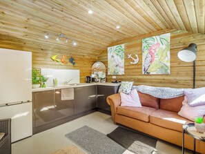 Eine moderne Küche mit Holzboden, einer Couch und Kunstwerken an den Wänden.