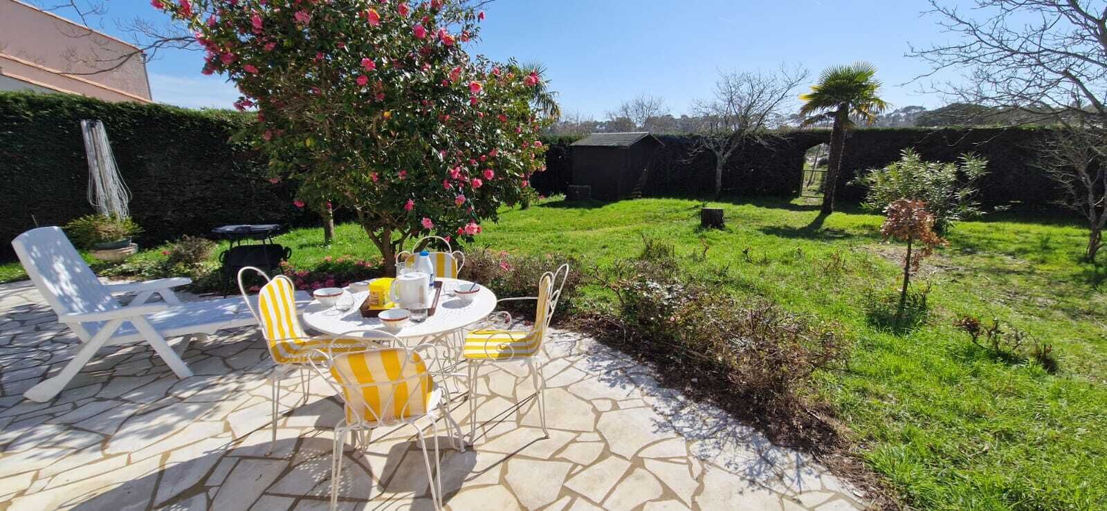 Une terrasse avec des meubles d’extérieur, une table et des chaises.