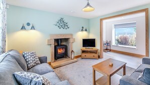 A living room with a fireplace, a television, and a large window. - 2 bedroom accommodation in Risplith, near Ripon (Risplith, near Ripon)