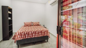 Een slaapkamer met een bed, een kledingkast en een airconditioning.