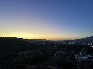 Un quartier résidentiel avec des maisons et un paysage vallonné, au crépuscule.