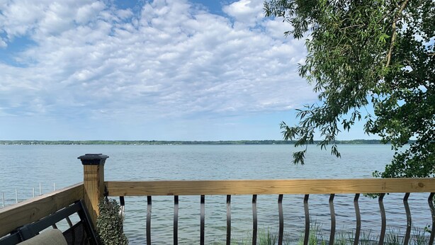 A wooden deck with a bench and a railing overlooking a calm lake. - SEE SOLAR ECLIPSE IN CTR OF PATH AT A BEAUTIFUL LAKEFRONT HOME.  NO CITY LIGHTS! (Cayuga)