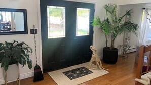 A room with a black door, a large potted plant, a small dinosaur skeleton, and a mirror on the wall. - SEE SOLAR ECLIPSE IN CTR OF PATH AT A BEAUTIFUL LAKEFRONT HOME.  NO CITY LIGHTS! (Cayuga)