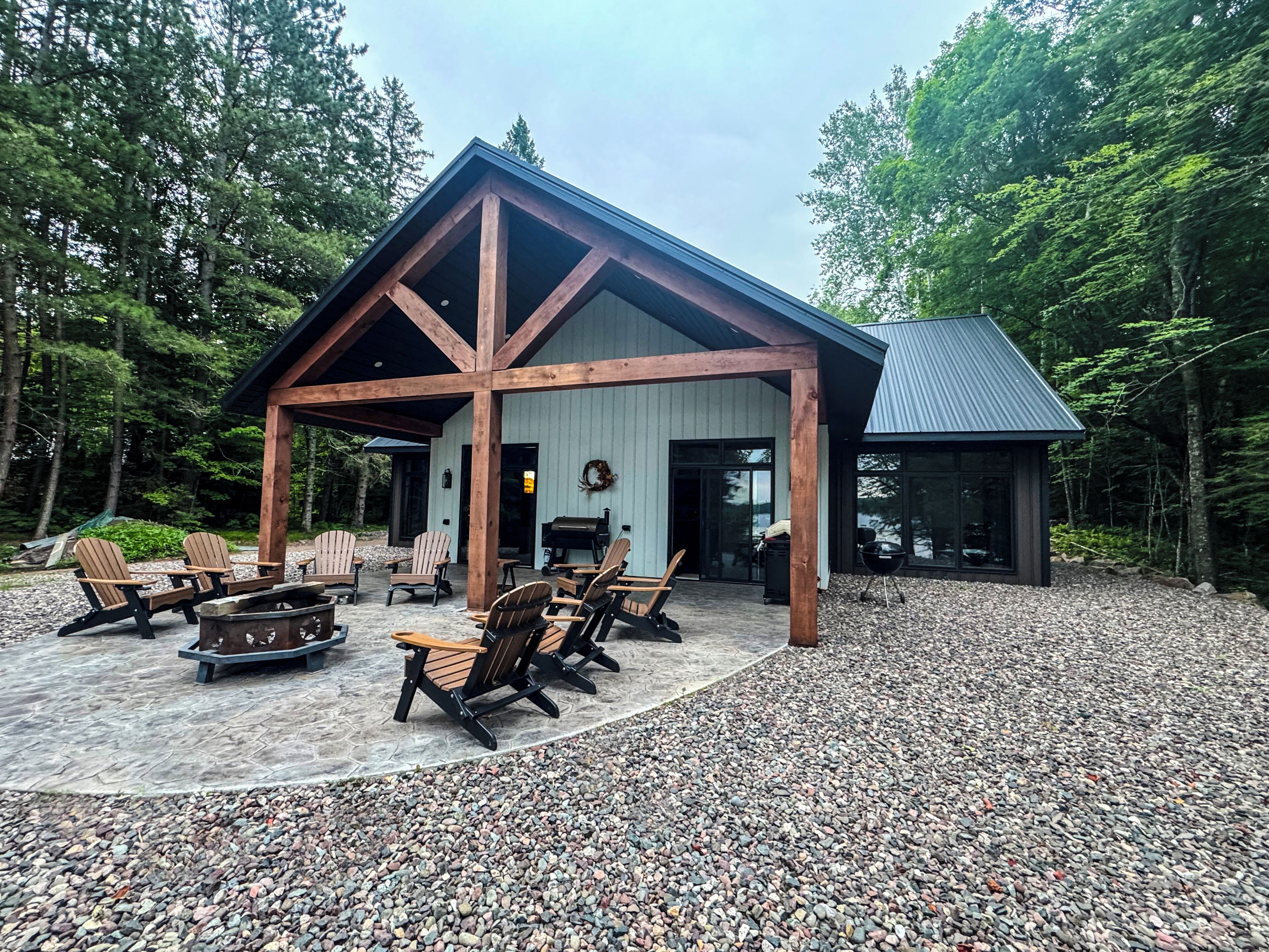 A lodge with a covered patio, outdoor seating, and a barbecue area.