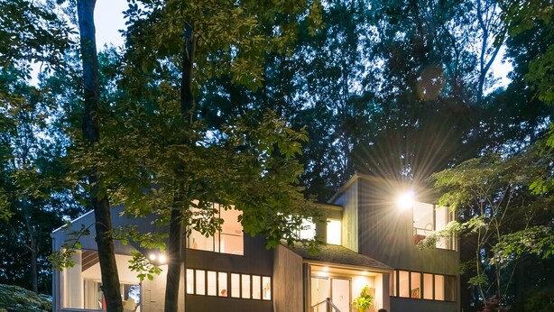 Een modern huis met een pad van stenen dat naar de ingang leidt.