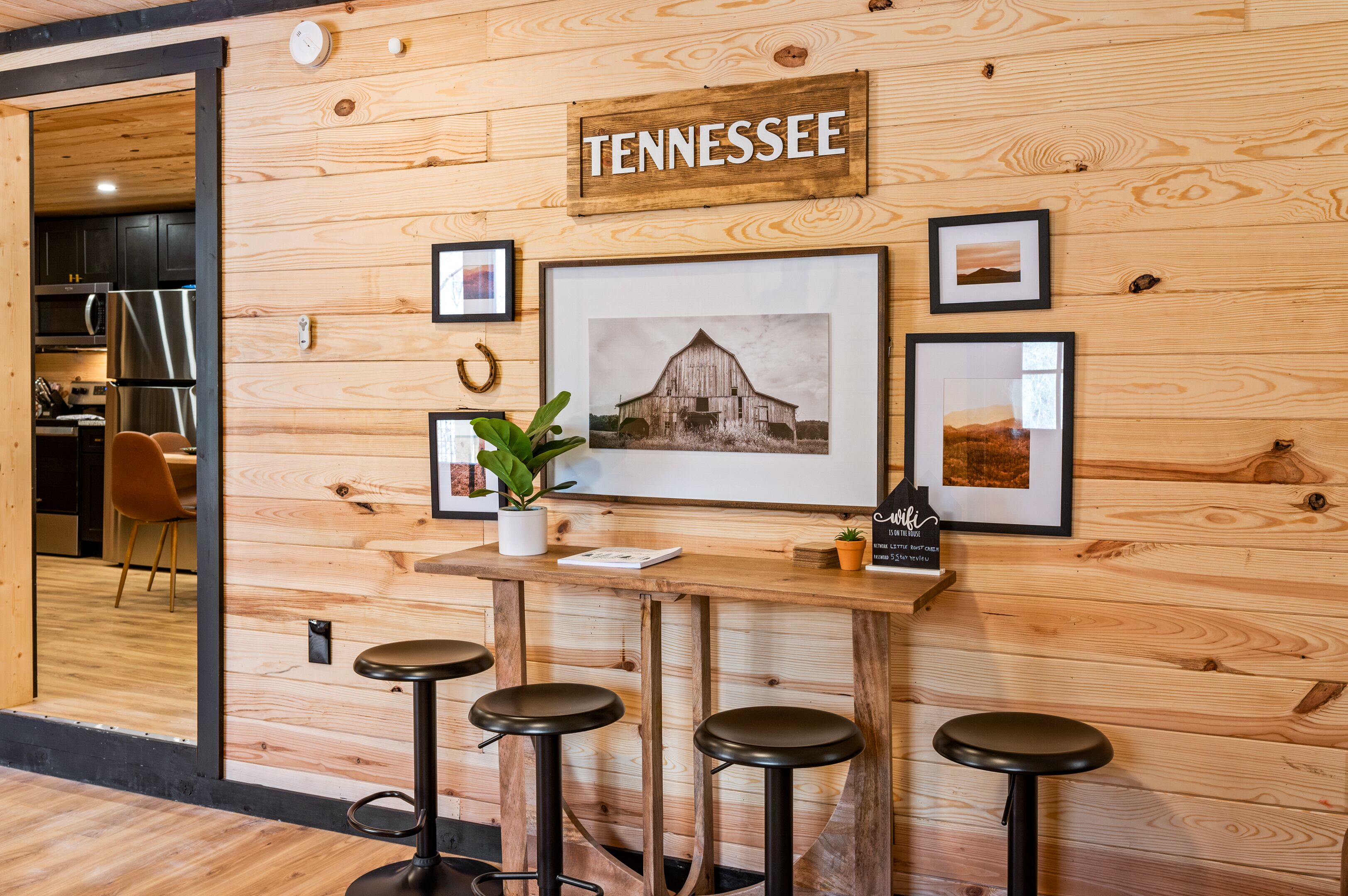 A wooden reception desk with a Tennessee sign, framed pictures, and a potted plant.