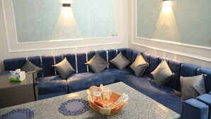 A modern living room with a blue sectional sofa, a granite coffee table, and a basket with items. - crystala guest house (Aswan)