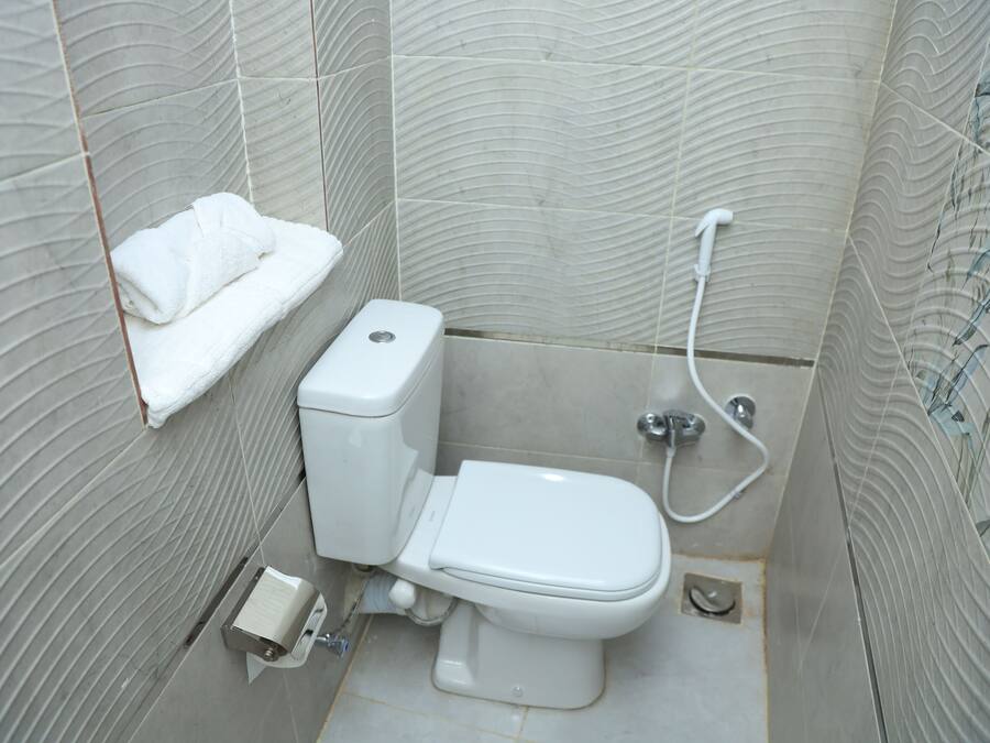 Un baño con inodoro, toallero y ducha.