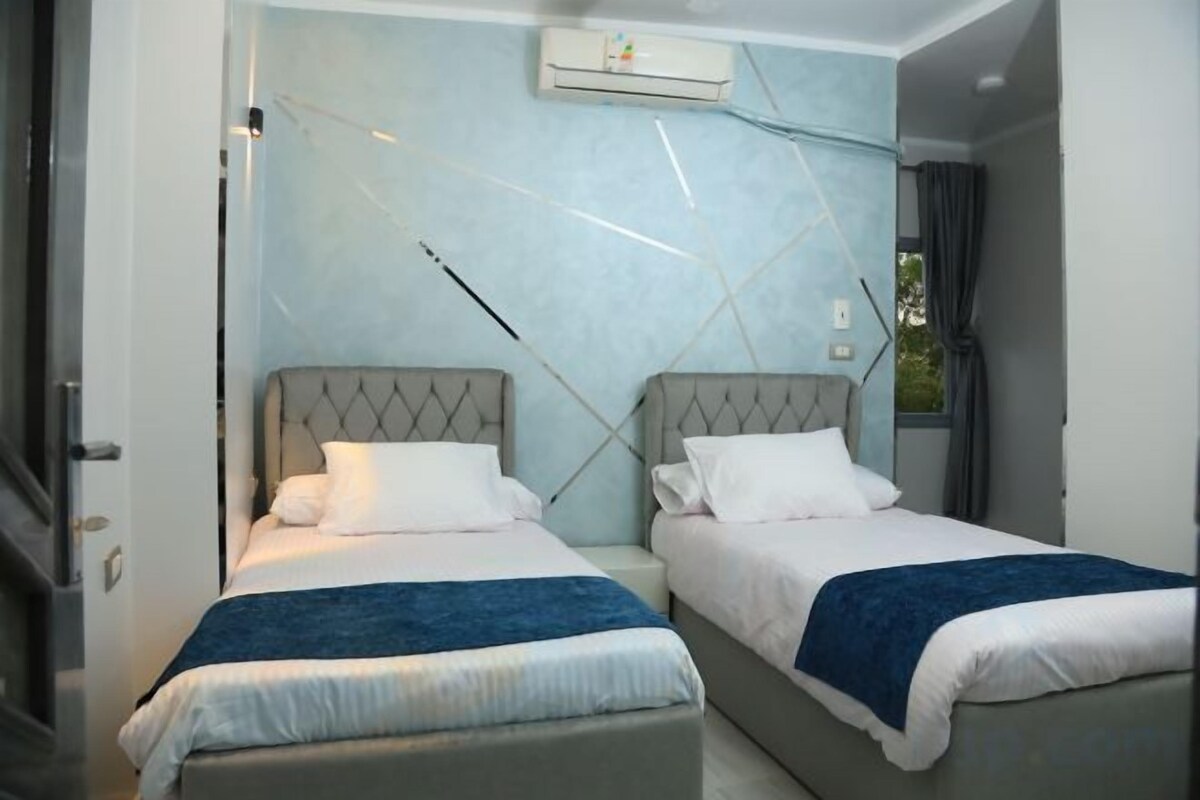 Una habitación de hotel con dos camas, diseño moderno y aire acondicionado.