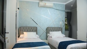 A hotel room with two beds, a large window with curtains, an air conditioning unit, and a modern design. - crystala guest house (Aswan)