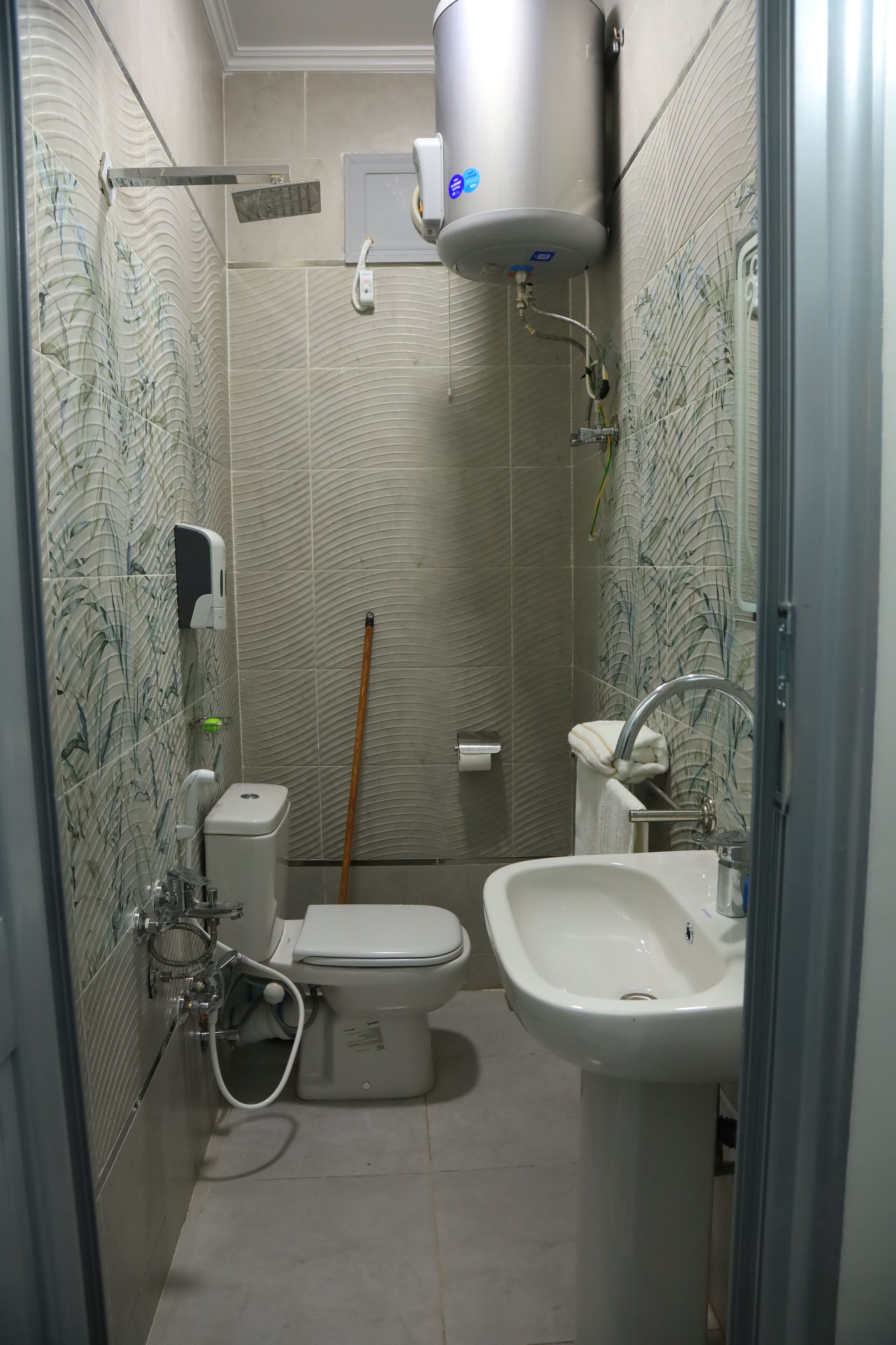 A bathroom with a toilet, sink, and a water heater.