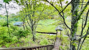 A wooden staircase leading to a gazebo in a lush, green park with a grassy field and trees in the background. - NOT YOUR GRANDMA’S CABIN! King Loft, WIFI, Game Room, Hot Tub & Fire Pit! (Almond)
