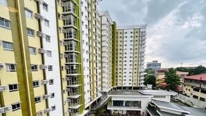 A high-rise residential building with two swimming pools, surrounded by greenery and a cloudy sky. - 1 Br condo T2-8H (Cagayan de Oro)