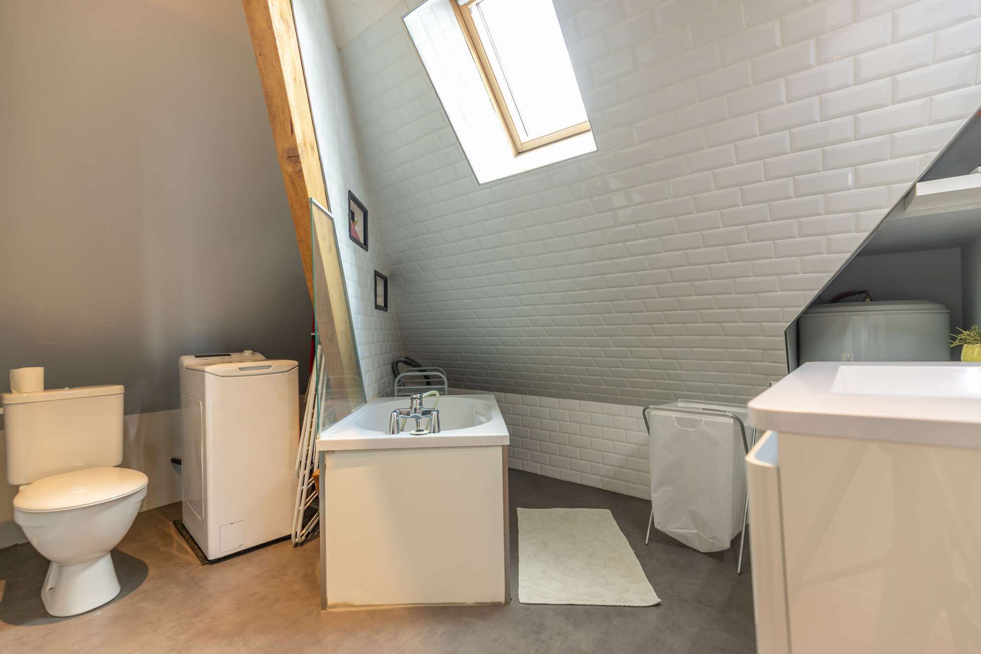 Une petite salle de bain moderne avec des toilettes blanches, un lavabo et un espace douche.