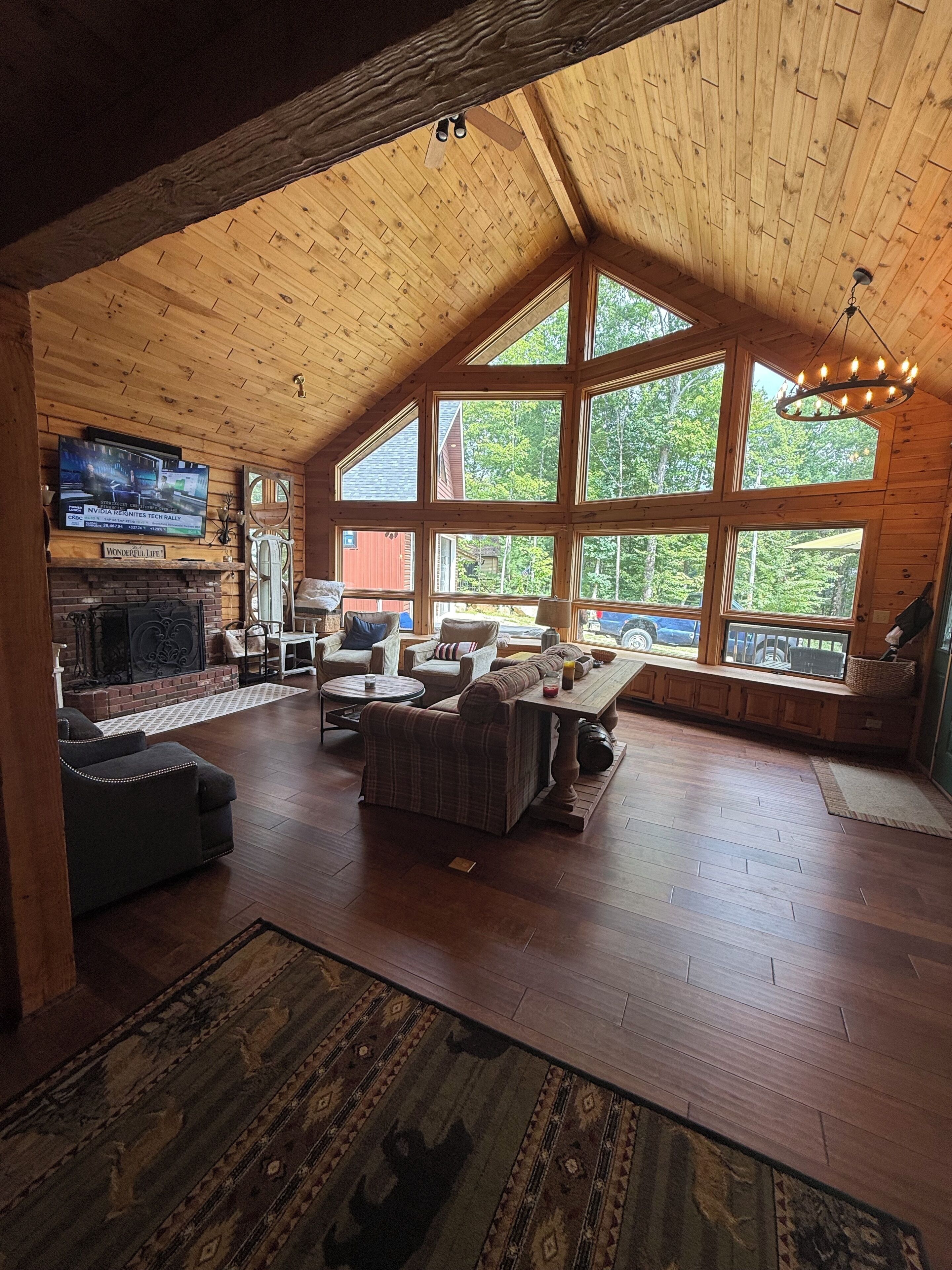 A spacious living area with a fireplace, comfortable seating, and large windows offering a view of the outdoors.