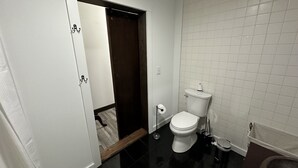 Une petite salle de bain propre, équipée de toilettes, d’un bidet et d’une poubelle.