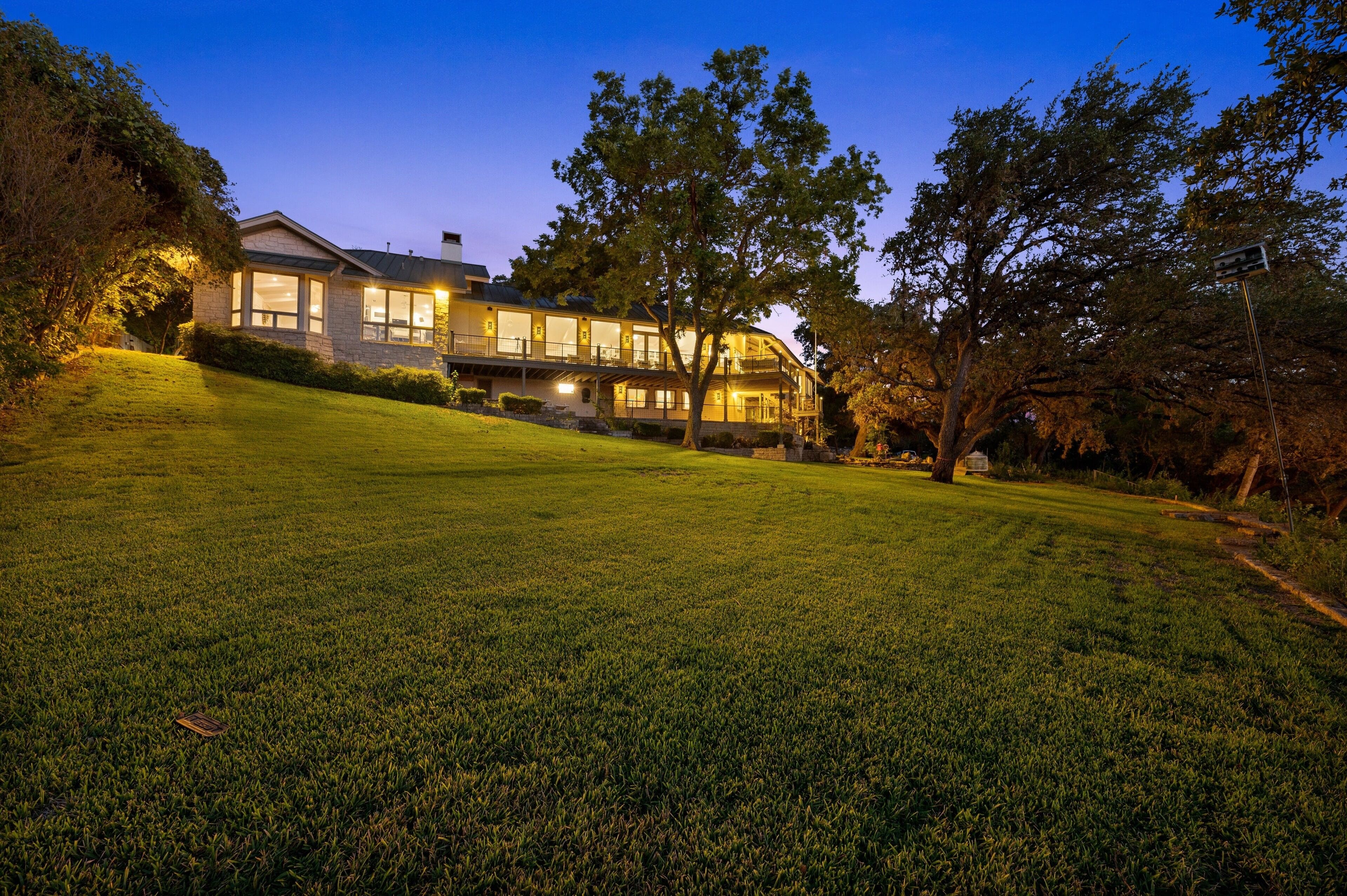 A large, two-story house with a well-maintained lawn and trees.