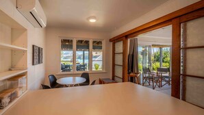 Une pièce spacieuse avec une grande table, des chaises et une vue sur l’extérieur par une fenêtre.