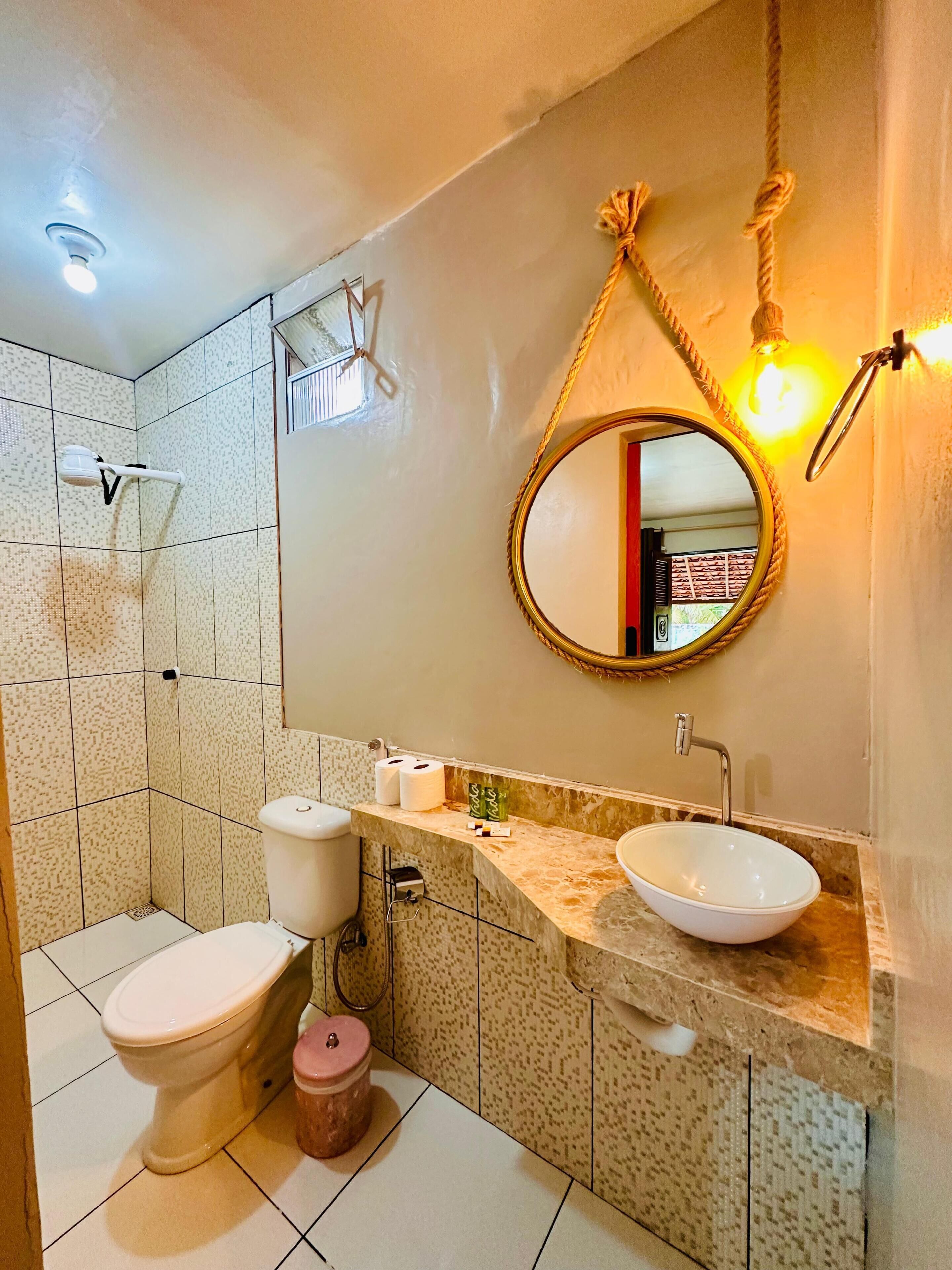 Un bagno con il water, un lavandino e uno specchio.