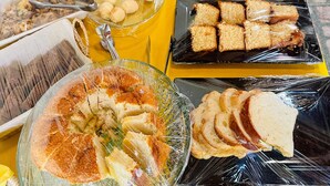 Een buffet met diverse soorten eten, waaronder brood, gebak en fruit.