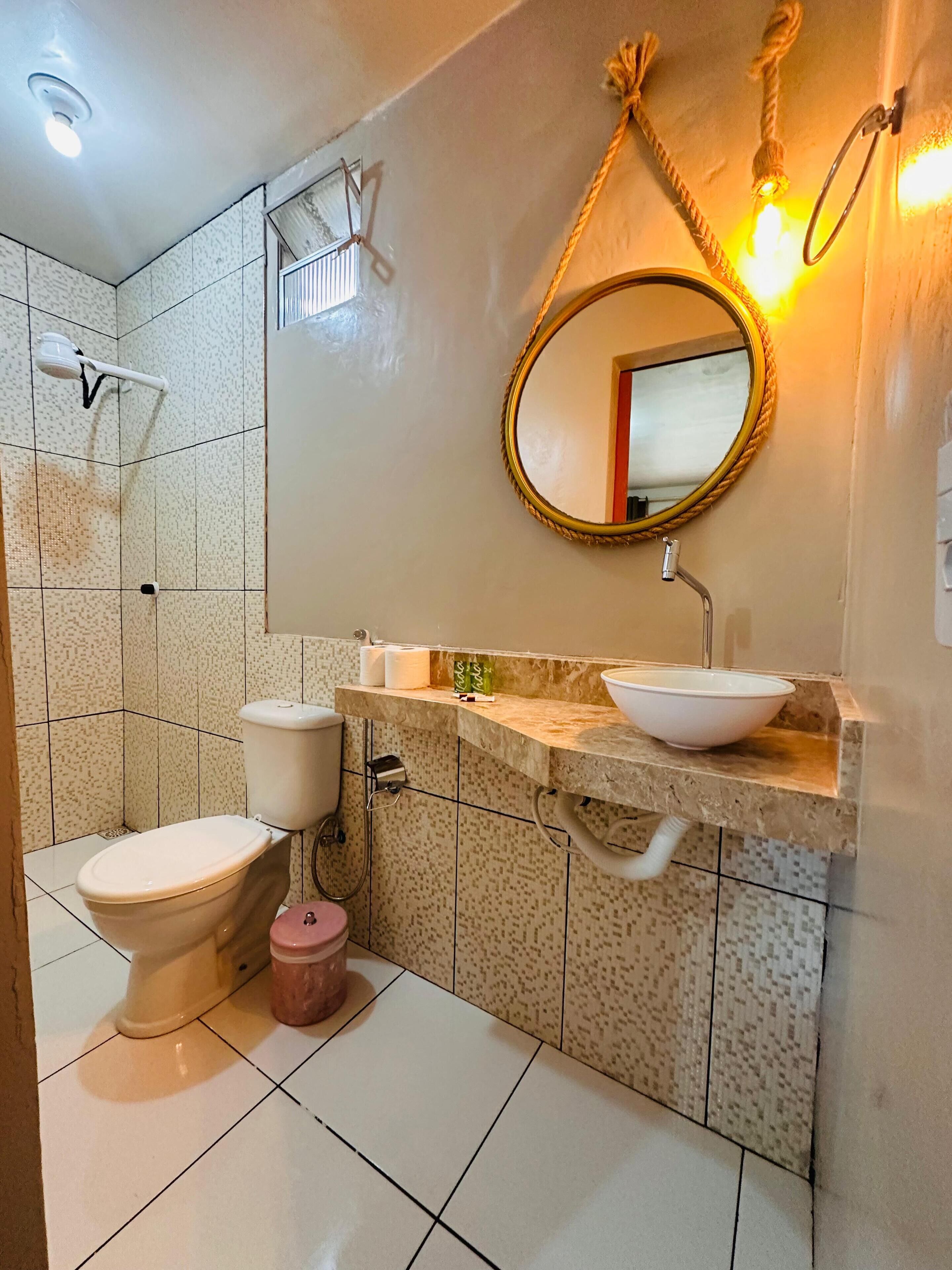 A bathroom with a toilet, sink, and shower.