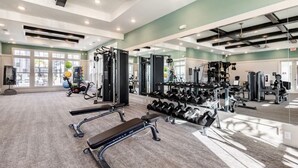 A gym with exercise equipment, benches, and dumbbells. - Boho Chic Luxury Retreat Minutes to Theme Parks, Restaurants and Entertainment. (Kissimmee)