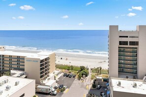 Un hôtel de grande hauteur donnant sur une plage et offrant une vue dégagée sur l’océan.