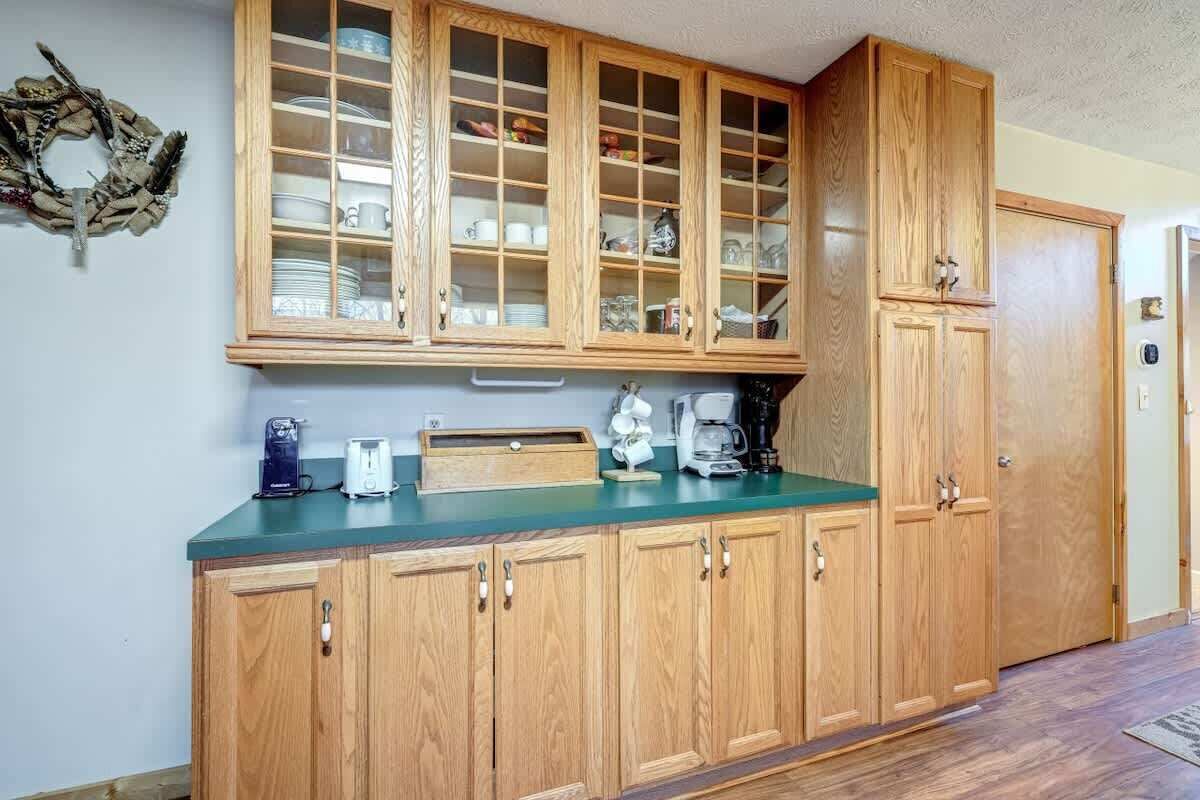 A kitchen with wooden cabinets, a green countertop, and various appliances.