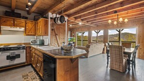 Una cocina amplia con armarios de madera, una isla central y un comedor con vistas.