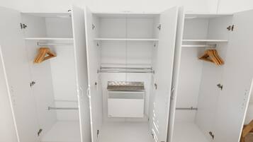 A white walk-in closet with multiple shelves, a hanging rod, and a built-in heater.