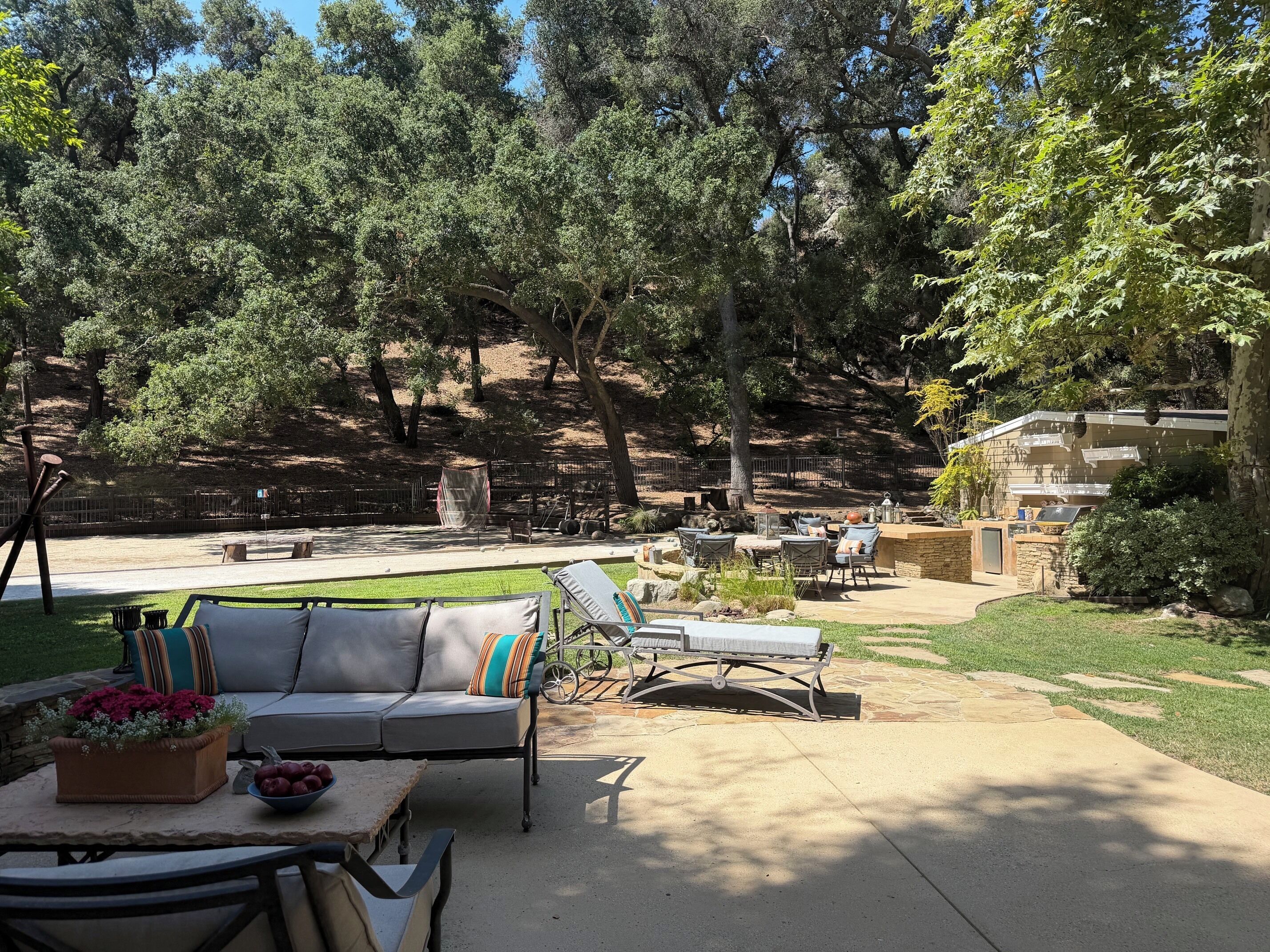 An outdoor patio area with a sofa, chairs, and a dining table.