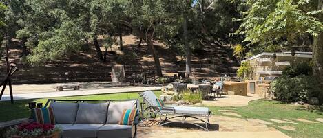 An outdoor patio area with a sofa, chairs, and a dining table.
