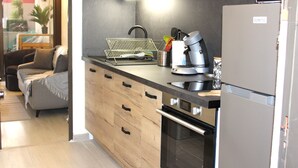 A modern kitchen with wooden cabinets, a stainless steel sink, and a built-in oven. - Les Terrasses de Cassis (Cassis)