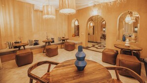 A spacious lobby with high ceilings, multiple seating areas, and large chandeliers. - Riad Villa Amood (Taouz)