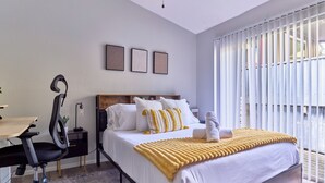 Ein modernes Schlafzimmer mit Bett, Schreibtisch und Stuhl.