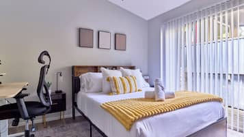 Une chambre à coucher moderne avec un lit, un bureau et une chaise.
