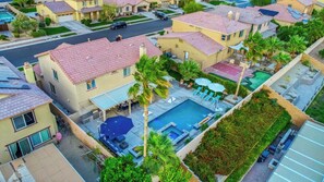 A residential area with multiple houses, a swimming pool, and a street.